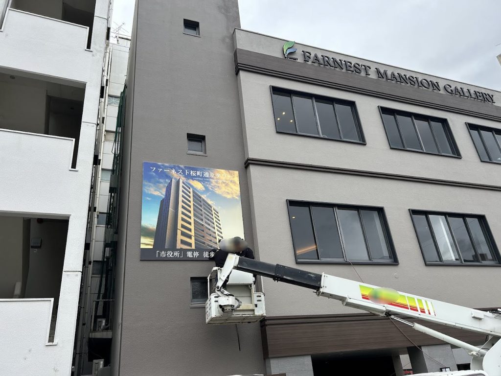 高所作業車を使用した壁面サイン施工の様子