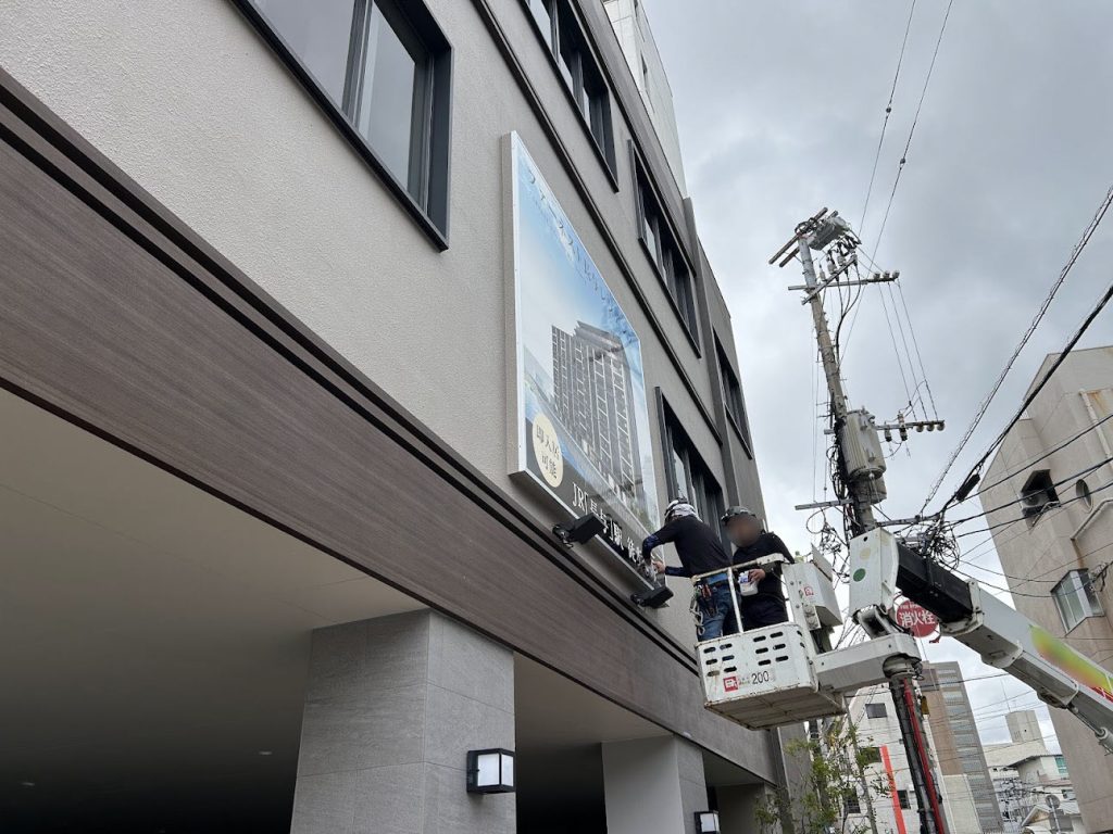 高所作業車を使用した壁面サイン施工の様子