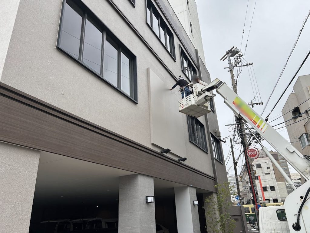 高所作業車を使用し壁面サイン施工
